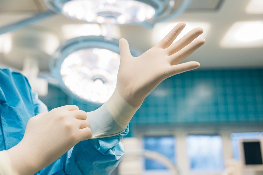 Dental assistant positioning an intraoral X-ray tube head at the chair